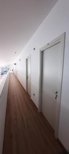 a hallway with white walls and a wooden floor at Casa di ALTAVILLA in Alba