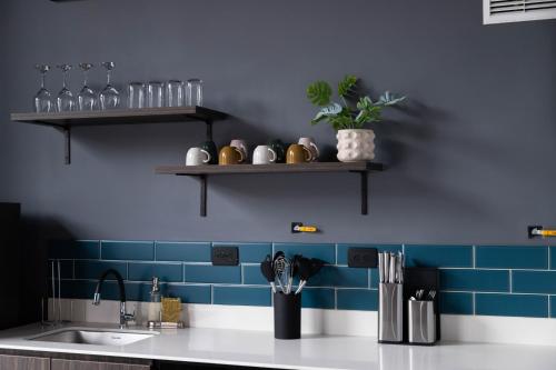 a kitchen counter with a sink and a blue wall at Royal Living Poblado in Medellín