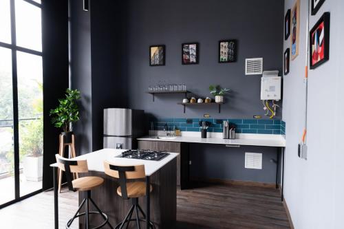 a kitchen with black walls and a counter with stools at Royal Living Poblado in Medellín