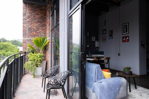 a balcony with a couch and chairs on a balcony at Royal Living Poblado in Medellín