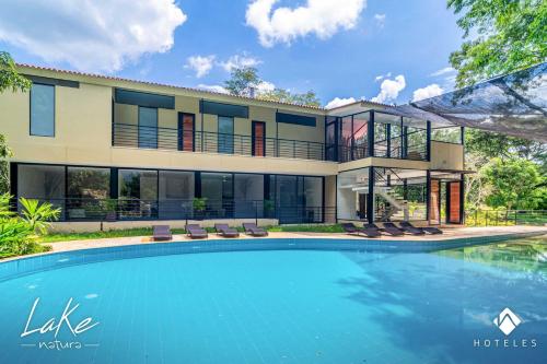a house with a swimming pool in front of it at Natura Lake - Casa Campestre in Anapoima