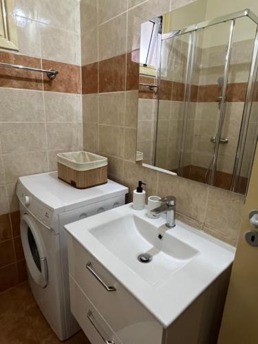a bathroom with a sink and a washing machine at Carisa Holiday rooms in Larnaca