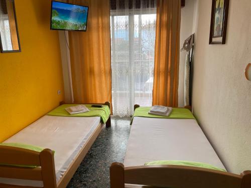 アスプロヴァルタにあるKLetnikoviのテレビ、窓が備わるドミトリールームのベッド2台分です。