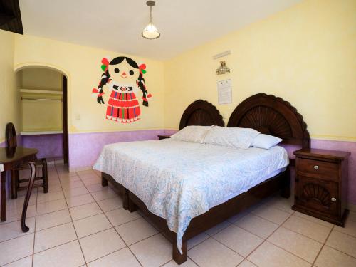 um quarto com uma cama com um quadro na parede em Hotel Quinta Mirador Zacualli em Bernal