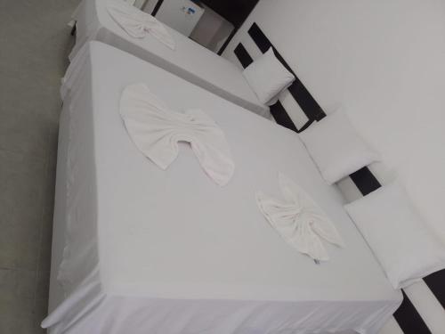 a white bed with white sheets on it at Hotel Porto Brasília in Porto Seguro