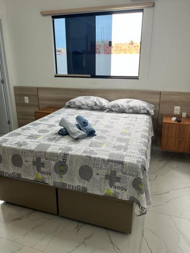 a bed with a blue stuffed animal on top of it at Um Paraíso em Paripueira in Paripueira