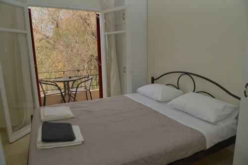 1 dormitorio con 1 cama y balcón con mesa en little apartment in kanoni en Análipsis