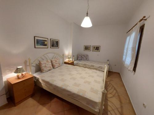 Elli's house في إيريسوس: غرفة نوم صغيرة مع سرير وموقف ليلي