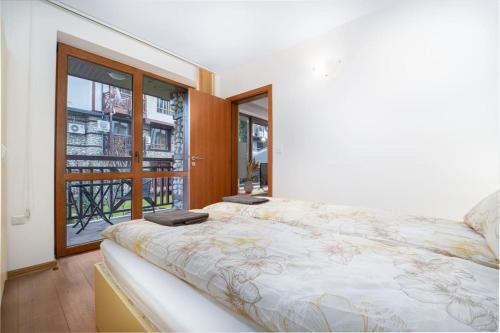 Un dormitorio con una cama grande y una ventana en Snow Legend Apartment with terrace en Bansko