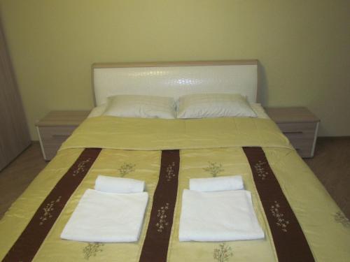 ヴォログダにあるАпартаменты на Новгородской 4のベッド1台(タオル2枚、枕2つ付)