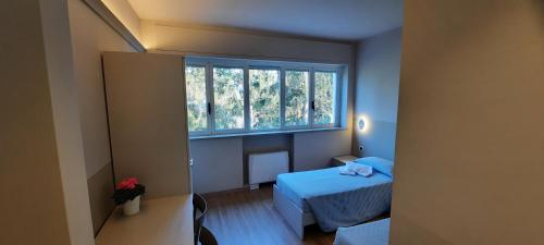 a small room with two beds and a window at Casa di ALTAVILLA in Alba