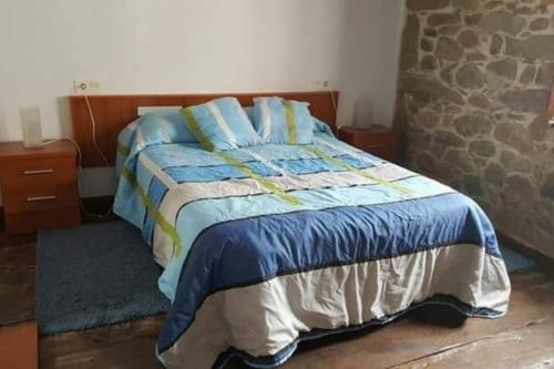 a bedroom with a bed with blue sheets and blue pillows at CASONA SARIEGO, APARTAMENTO in La Vega de Riosa