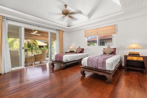 - une chambre avec 2 lits et un ventilateur de plafond dans l'établissement Beachfront Resort Villa Baan Tawan 3BR, à Lamai