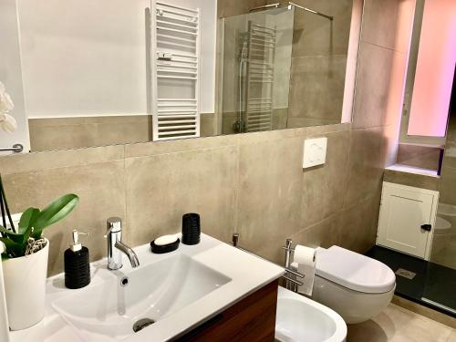 a bathroom with a sink and a toilet and a mirror at Casa con giardinetto al centro di Roma in Rome