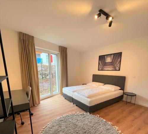 1 dormitorio con cama y ventana grande en helloYOU Apartments, en Ingelheim am Rhein