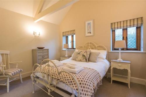 a bedroom with a large bed and a chair at Maristow Cottages, overlook Tamar Valley Dartmoor in Plymouth