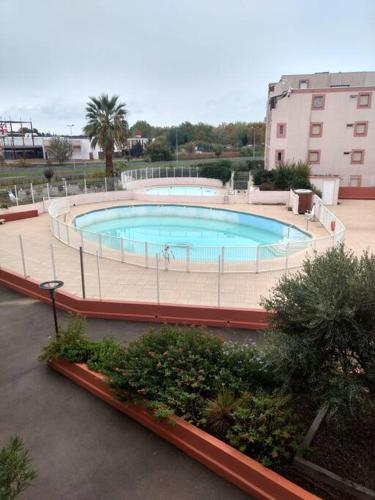 duży basen w środku budynku w obiekcie Superbe studio dans résidence avec piscine sans chambre mais couchage salle et lit superposé dans l'entrée w mieście Le Grau-du-Roi
