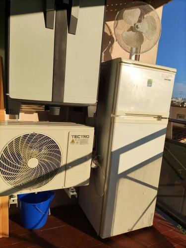 d'un ventilateur et d'un réfrigérateur à côté d'une fenêtre. dans l'établissement Superbe studio dans résidence avec piscine sans chambre mais couchage salle et lit superposé dans l'entrée, au Grau-du-Roi