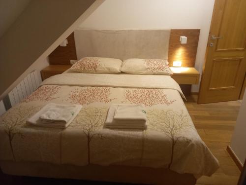 a bedroom with a bed with two towels on it at Vila Borova Zlatibor Apartman 501 in Zlatibor