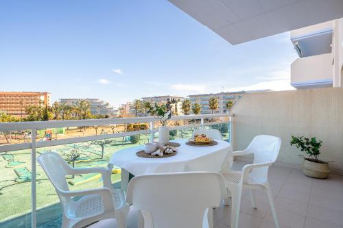 balcón con mesa blanca y sillas blancas en Alea Rentals - Los Juncos, en La Pineda