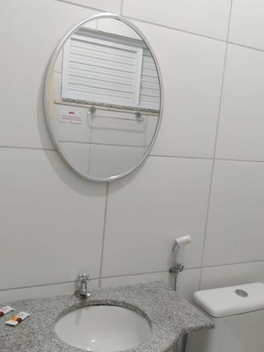 a bathroom with a mirror and a sink at Hotel Villa Real in Sobral