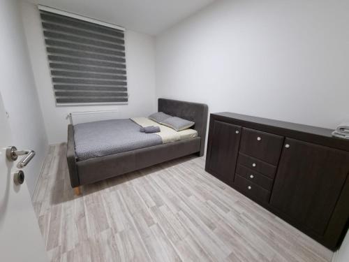 een kleine slaapkamer met een bed en een dressoir bij Silver city 1 in Jagodina