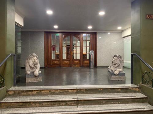 dos estatuas de leones frente a un edificio en Departamento Center en San Fernando del Valle de Catamarca