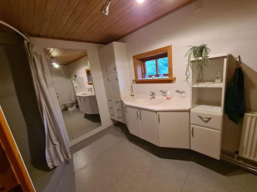 a bathroom with a sink and a toilet and a mirror at Hyggeligt gammelt hus i Vestmanna in Vestmanna