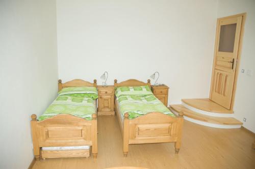 a pair of twin beds in a room at Penzion U Rychtářky in Holany