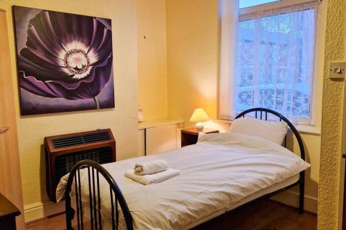 a bedroom with a bed with a towel on it at Tallis House, Sleeps 5, near City Centre, Free Parking, Long or Short Stays - by NMB Property in Manchester