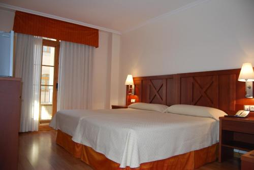 Säng eller sängar i ett rum på Hotel Meleiros