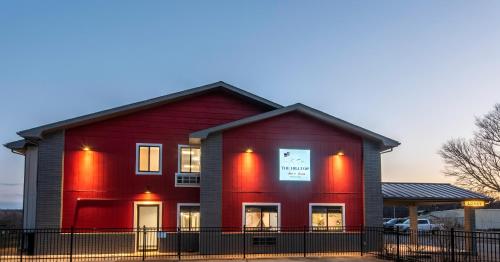 a red house with a sign in the window at Hilltop Inn & Suites in Grove
