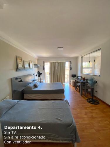 a bedroom with two beds and a desk in it at Sarmiento Monoambiente in Concordia