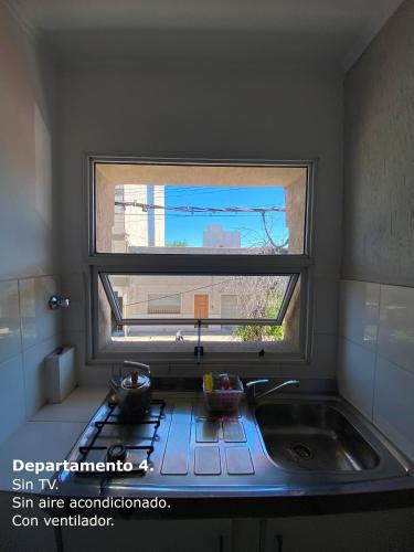 a kitchen with a sink and a window above a stove at Sarmiento Monoambiente in Concordia