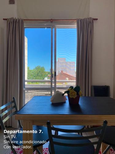 a dining room table with a view of a window at Sarmiento Monoambiente in Concordia