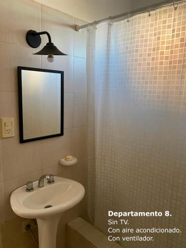 a bathroom with a sink and a shower with a mirror at Sarmiento Monoambiente in Concordia
