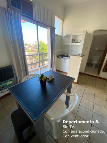 a kitchen with a table and a dining room with a window at Sarmiento Monoambiente in Concordia