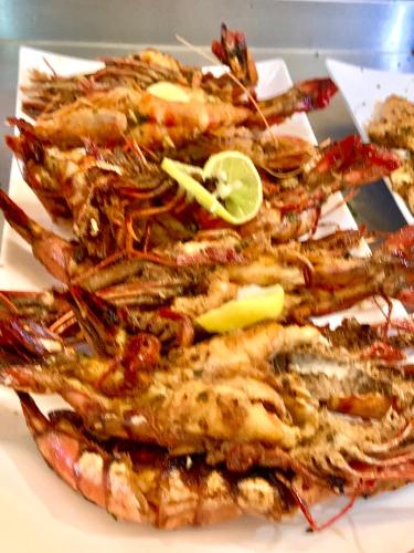 a pile of shrimp on a plate with a lime at Hibiscus House Gambia in Brufut