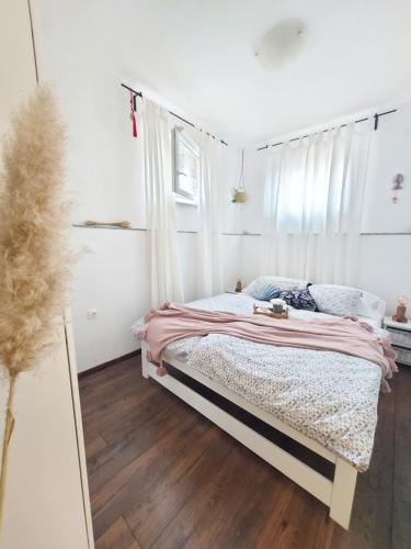 een slaapkamer met een bed met een roze deken bij Apartment46 in Mali Lošinj