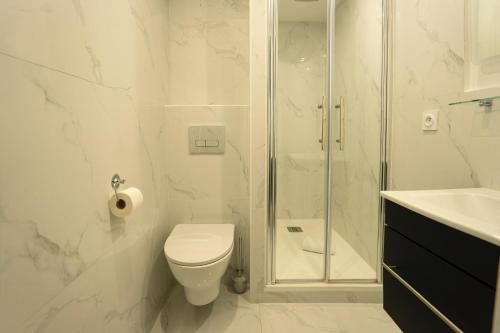 y baño con ducha, aseo y lavamanos. en Conde Chic Studio, en París