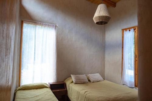1 dormitorio con 2 camas y ventana en Las de Barro en Lago Puelo