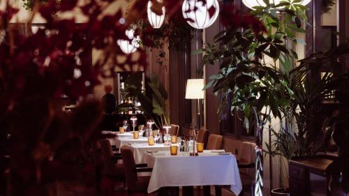 a dining room with tables and chairs and flowers at InterContinental Porto - Palacio das Cardosas by IHG in Porto