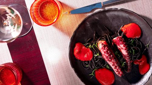 a black plate of food with strawberries on a table at InterContinental Porto - Palacio das Cardosas by IHG in Porto