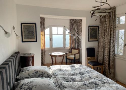een slaapkamer met een bed, een tafel en een raam bij Villa Sonnenburg in Bad Schandau