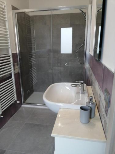 a bathroom with a shower and a sink and a tub at MAWA in Ferrara