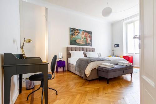 a bedroom with a bed and a desk and a piano at B&B Liberty Suite Milan in Milan