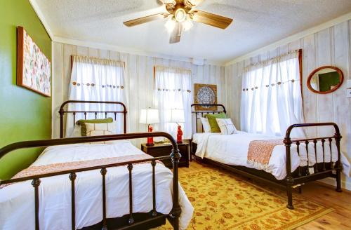 a bedroom with two beds and a ceiling fan at Lake of the Ozarks Vacation Home with Boat Dock in Gravois Mills