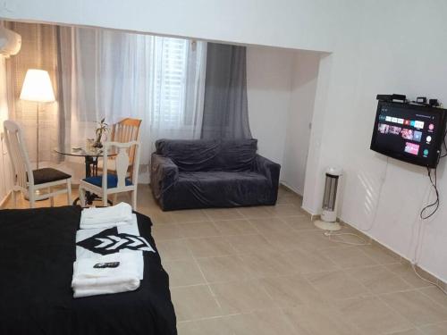 a living room with a couch and a tv at דירת נופש משמר הגבול 9 דירה 14 in Haifa