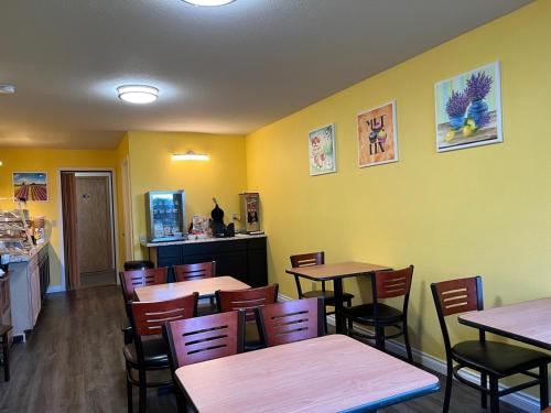 a restaurant with tables and chairs and yellow walls at Ocean Star Inn in Sequim
