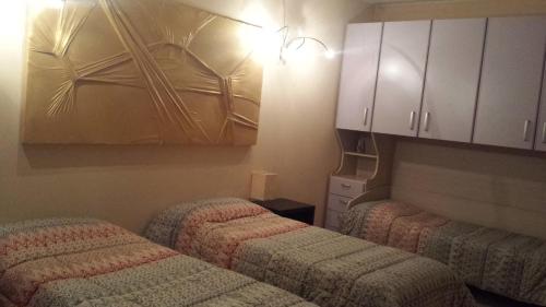 a room with two beds and a cupboard and cabinets at B&B Ai Prati in Bergamo
